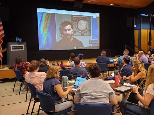 Teachers watch a screen showing Science Communication Fellow Brandon