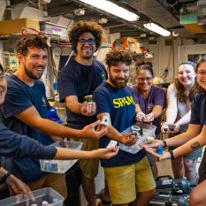 The science team retrieves their shrunken cups from the Wet Lab after the final DAP (Deep Autonomous Profiler) dive. 